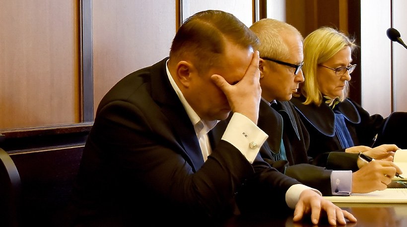 Kamil Durczok na sali rozpraw zasłania twarz
