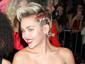 Miley Cyrus, pół kadru, w czerwonej wieczorowej sukience z wielkim dekolotem