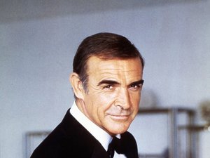 Sean Connery celuje z pistoletu, w czarnej muszce
