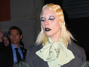 Lady Gaga w białej bluzce z żabotem i dziwnej pofalowanej fryzurze